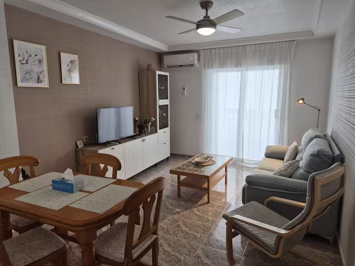Living room with dining table, sofa and balcony doors